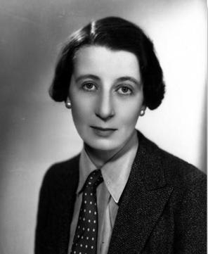 A black and white image of the author Josephine Tey. She is wearing a suit with a patterned tie.