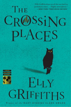 The cover of The Crossing Places by Elly Griffiths. It is a solid teal background, with the title and author's name in black text. In the center of the book is the silhouette of an owl.