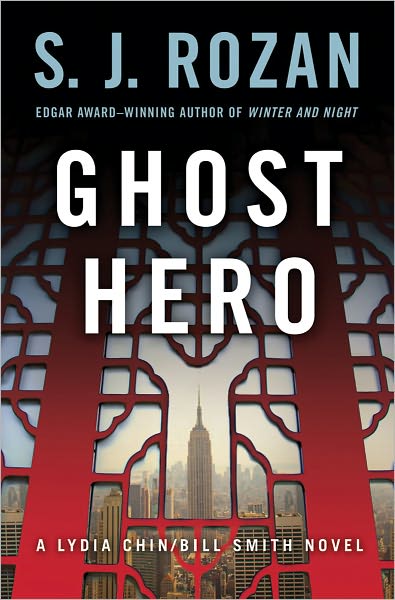The cover of Ghost Hero by S. J. Rozan. The author's name is at the top in pale blue capital letters, and the title is in capital letters, slightly larger and in white, in the middle of the cover. In small pale blue text, below the author name, reads "From the Edgar Award-winning author of 'Winter and Night.'" The bottom has small text that reads "A Lydia Chin/Bill Smith Novel" in white. The text is printed over a photograph of New York City as viewed through an intricate red gate, with the Empire State Building centered.